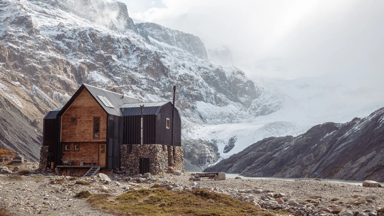 La casa de madera y piedra con el glaciar detrás