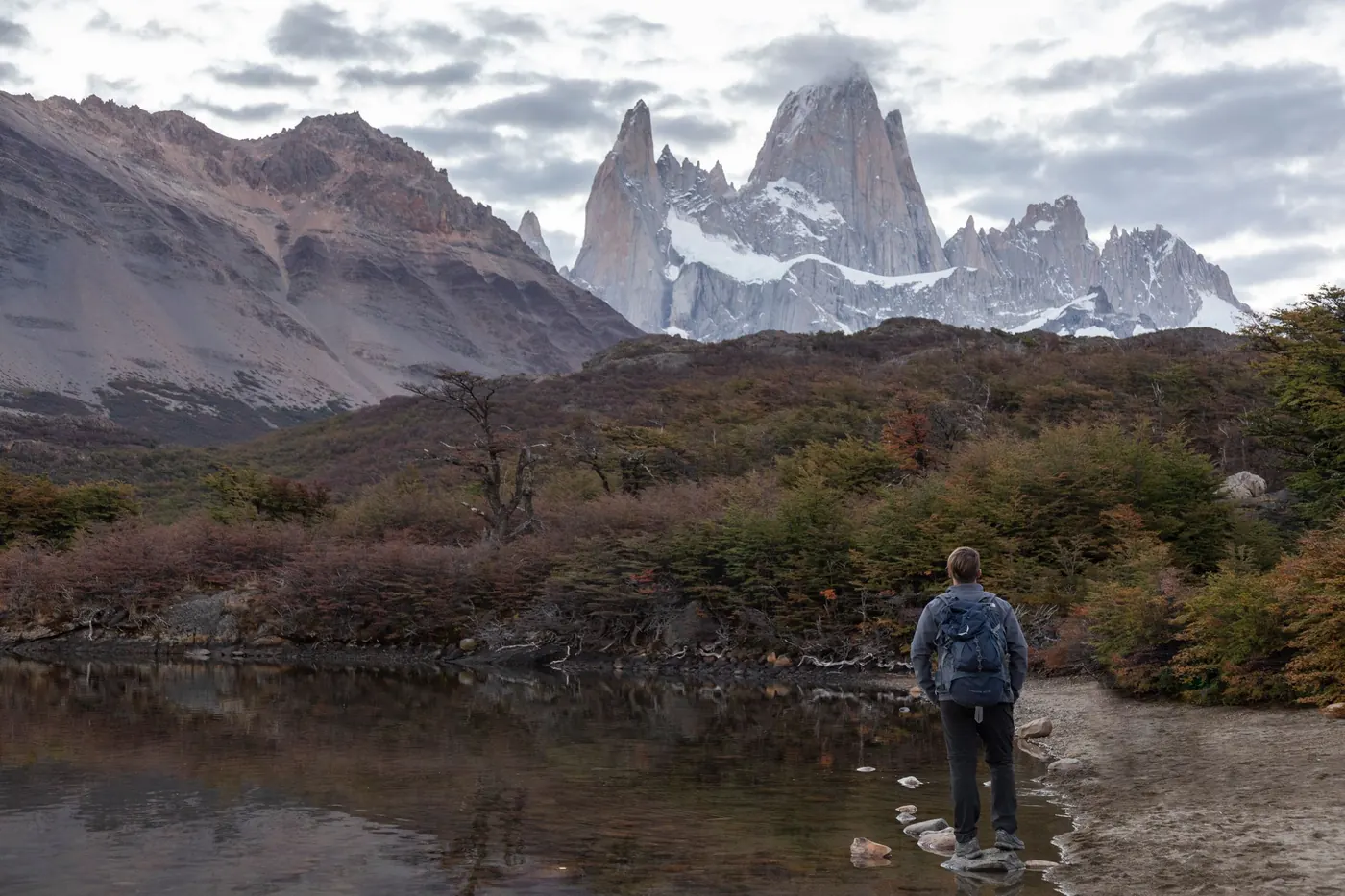Caminante frente a una laguna con el Fitz Roy al fondo